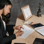 Advogada revisando documentos jurídicos em escritório moderno com iluminação natural