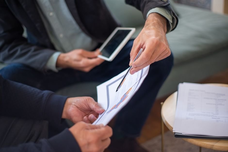 Análise detalhada de cláusulas para revisão de pensão. Advogado e cliente revisando cláusulas contratuais em um ambiente de escritório colaborativo