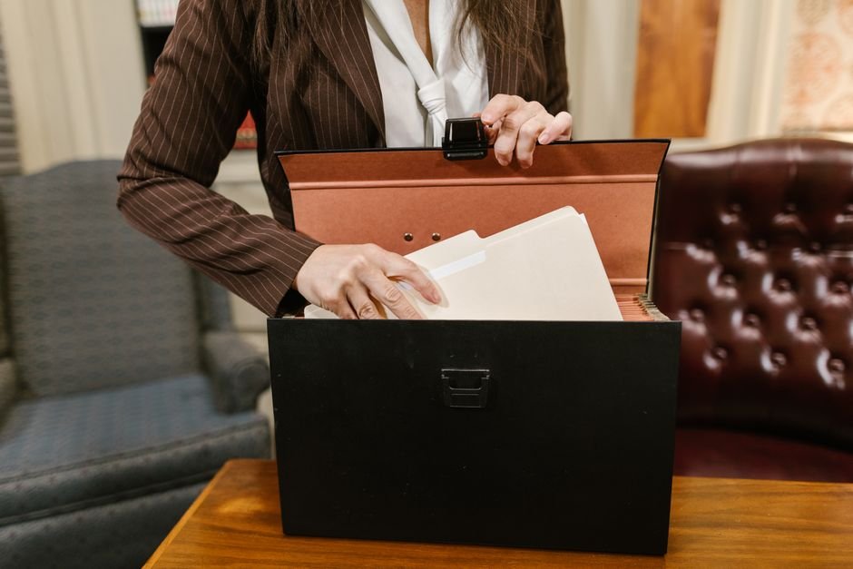 Conferência de documentos antes do início do processo. Profissional do direito conferindo petição inicial em mesa de trabalho organizada