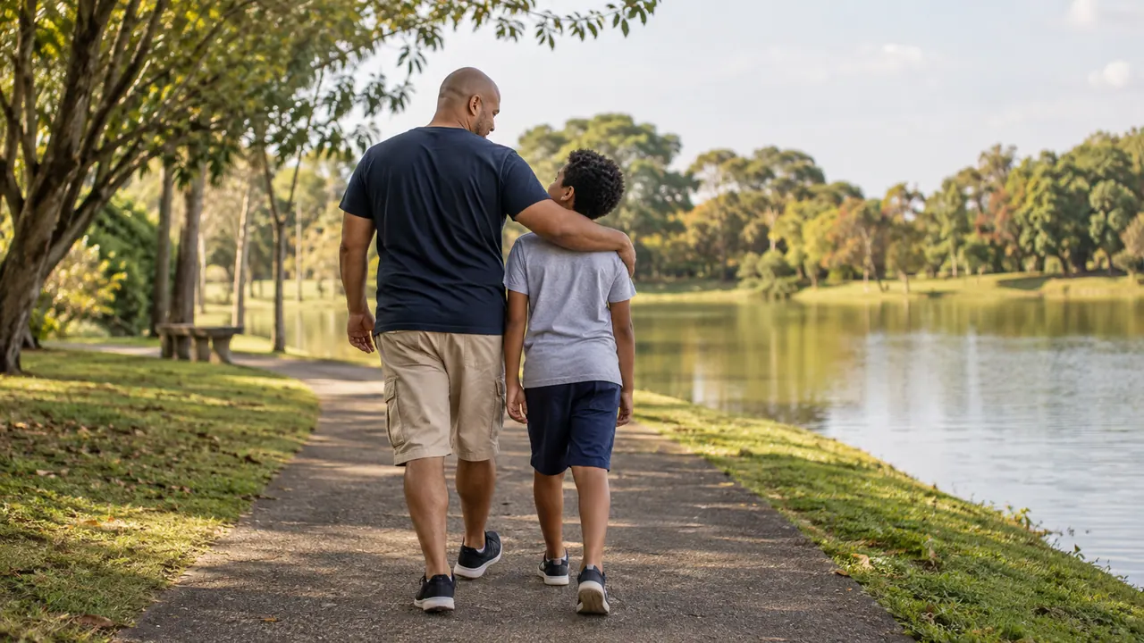 Pai e filho caminham juntos à beira de um lago; fotografia ilustrativa